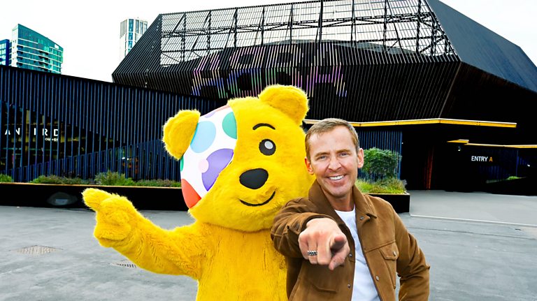 Pudsey and a man in front of an arena with the words ABBA written in lights