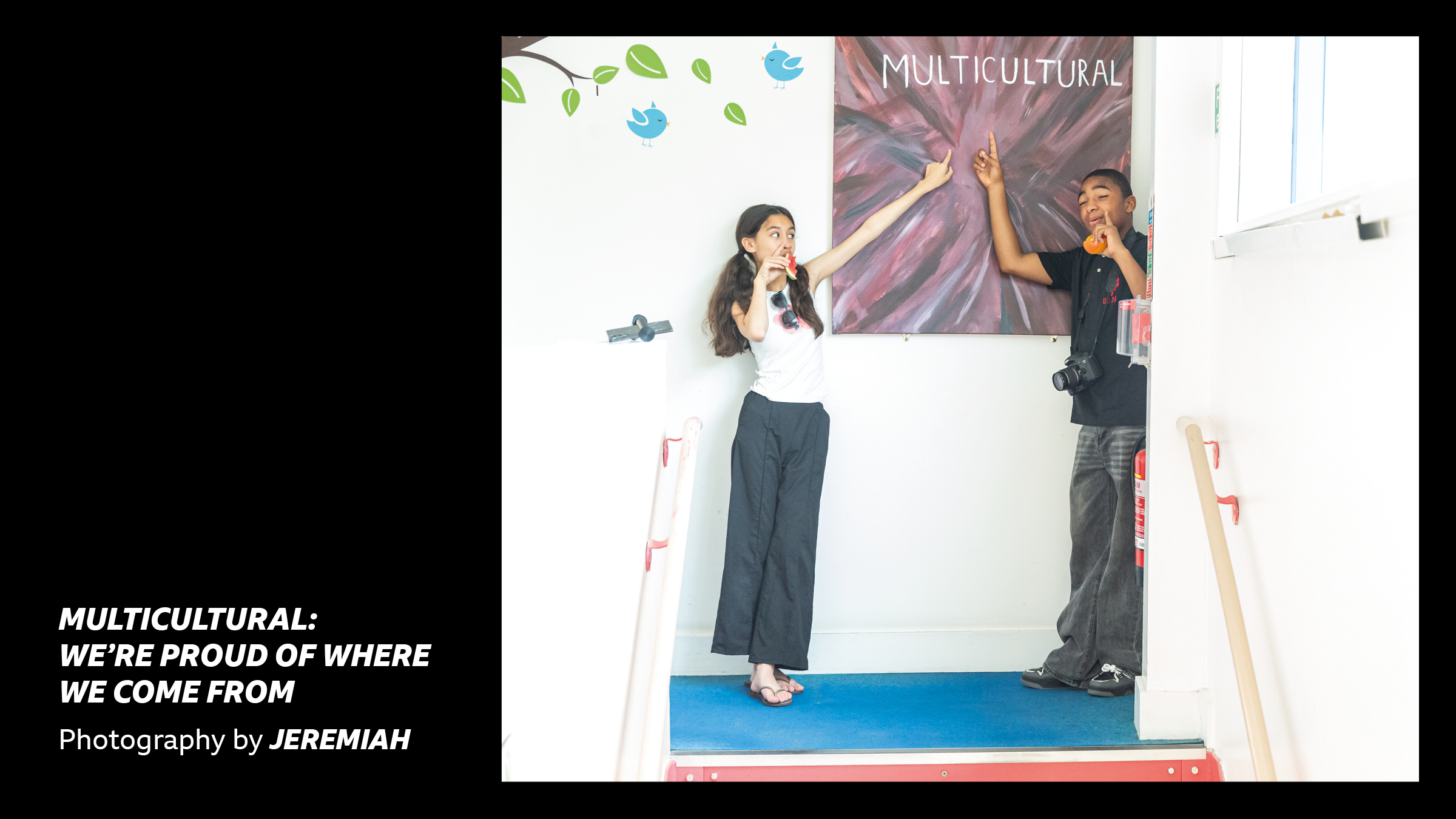 'Multicultural: We're proud of where we come from - Photography by Jeremiah' - Two young people pointing up at a sign which reads 'Multicultural'