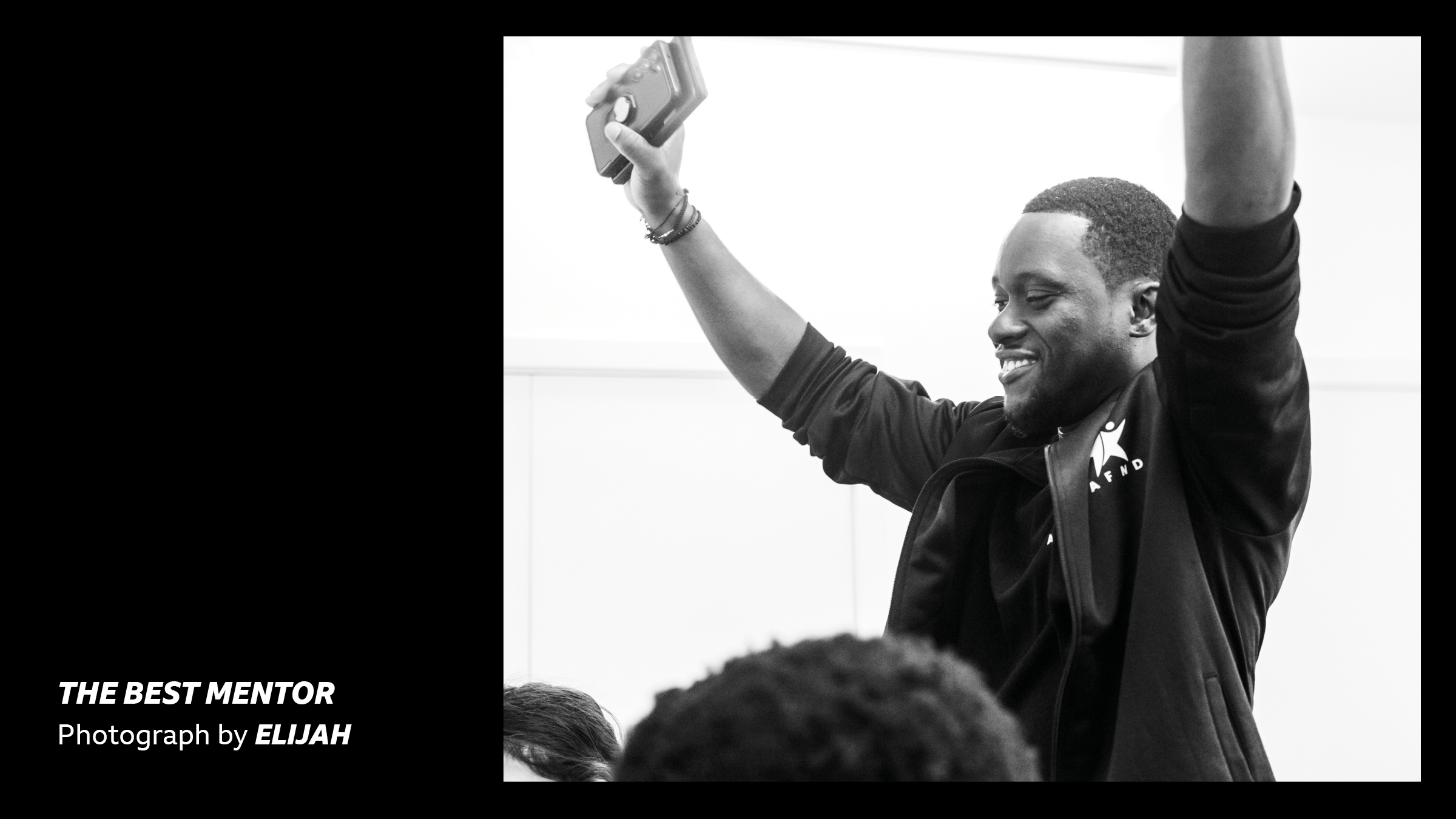 'The Best Mentor - Photograph by Jeremiah' A young man thrusting his arms at the sky, photographed in black and white